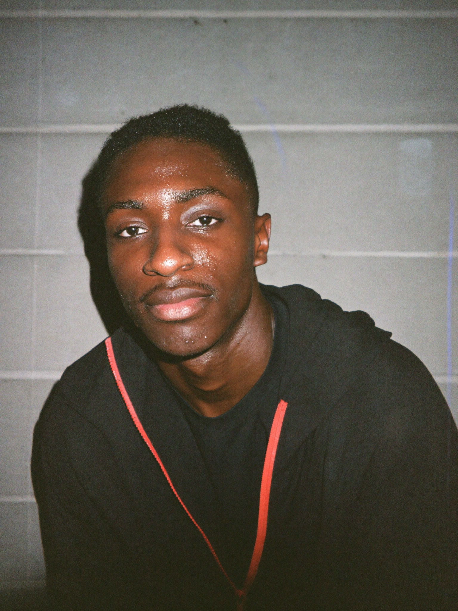 Portrait — direct flash, concrete, eye contact.